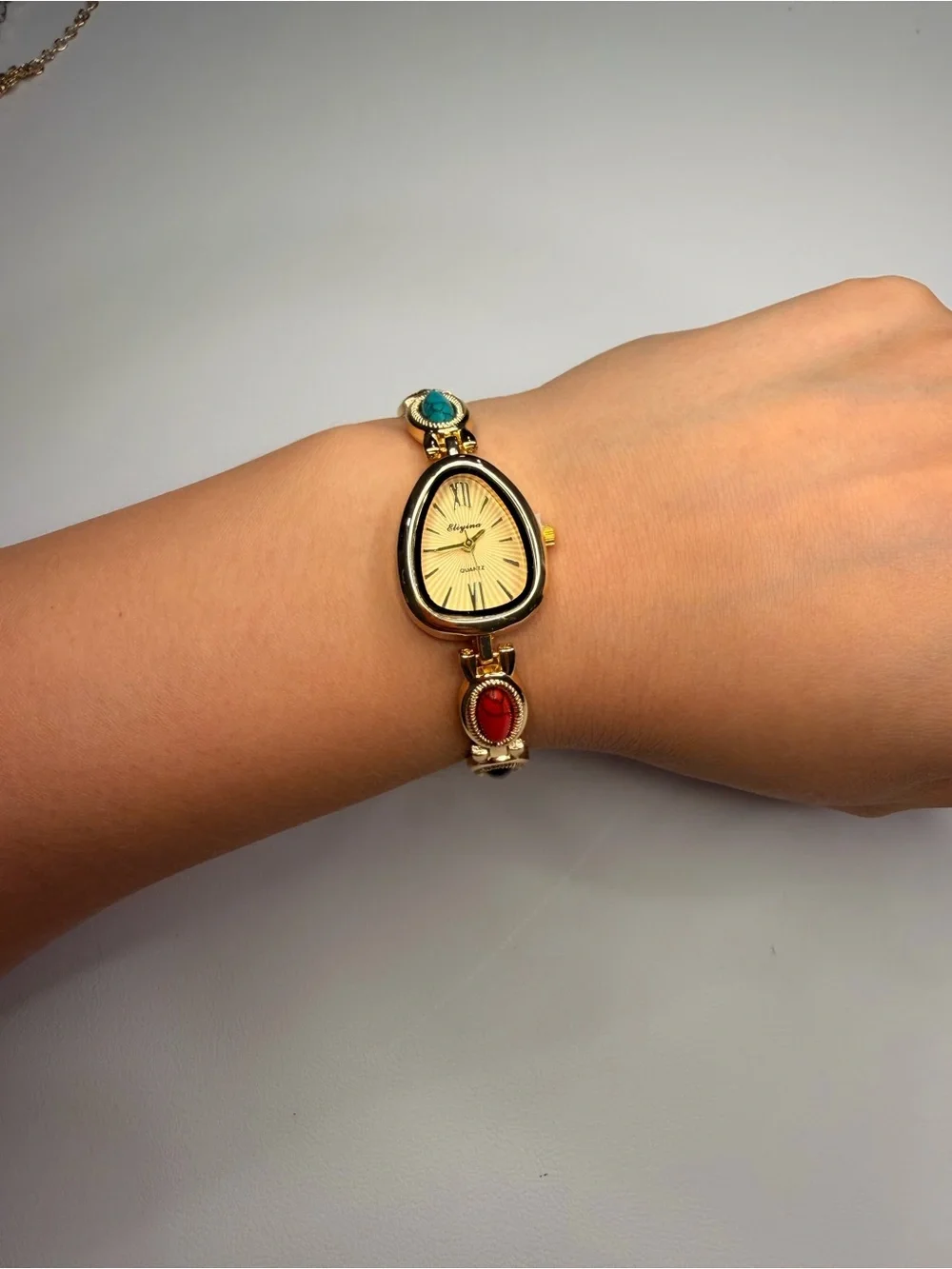 Gold Teardrop Dial Bracelet Watch with Red, Black and Turquoise Accents